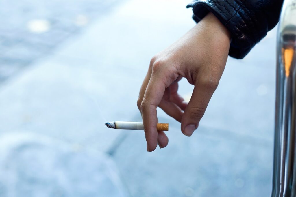 Woman holding a lit cigarette in her hand