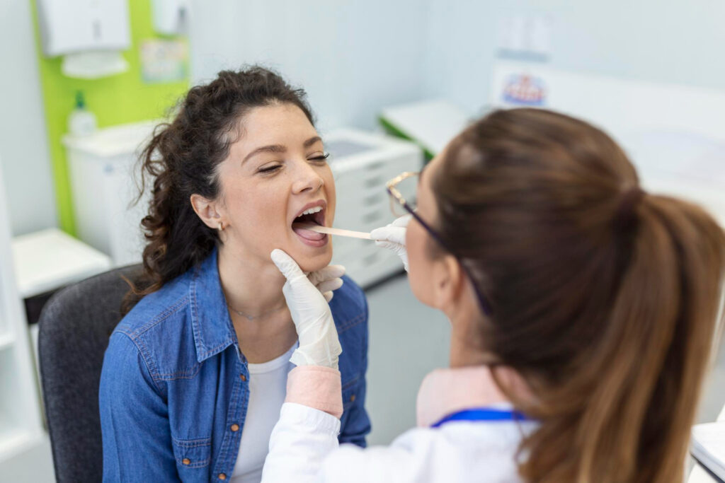 A female dentist performs an oral health exam on a female patient