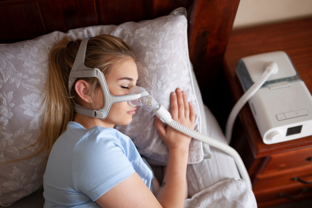 A woman wears a Continuous Positive Airway Pressure (CPAP) device