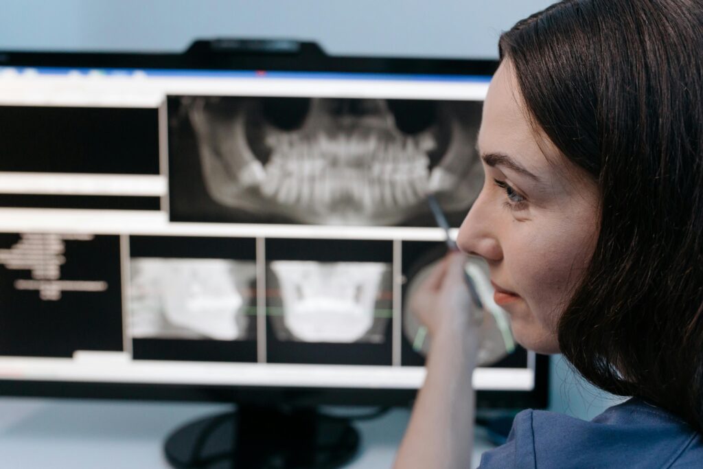 Person analyzing dental X-rays on a computer screen.