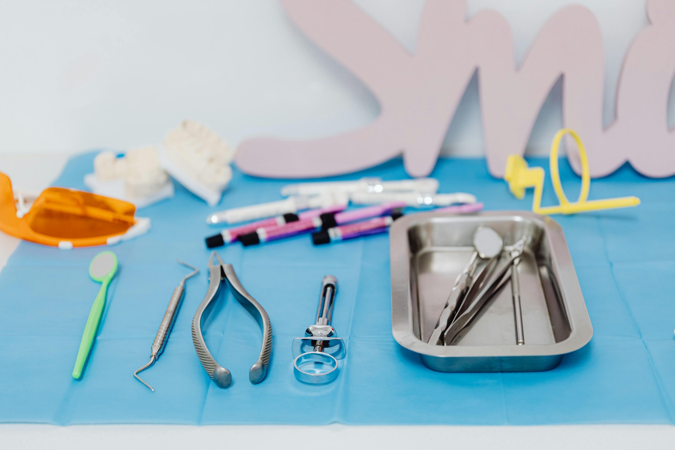 Dental tools arranged on a blue cloth in a dental office.