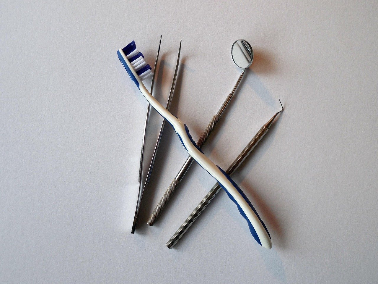 Dental tools and toothbrush on a white background.