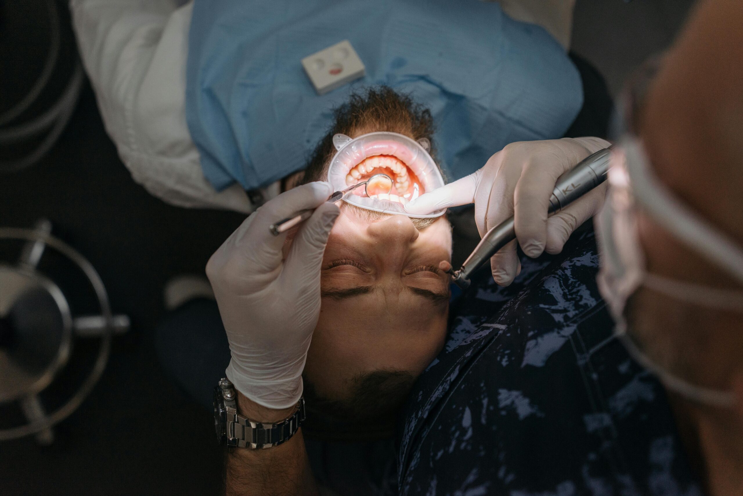 Dentist examining a patient's mouth with tools.