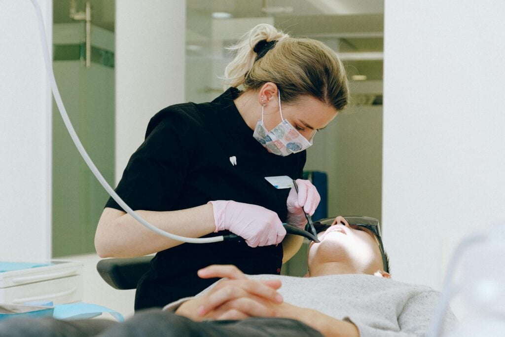 Dentist examining a patient's mouth in a clinic.