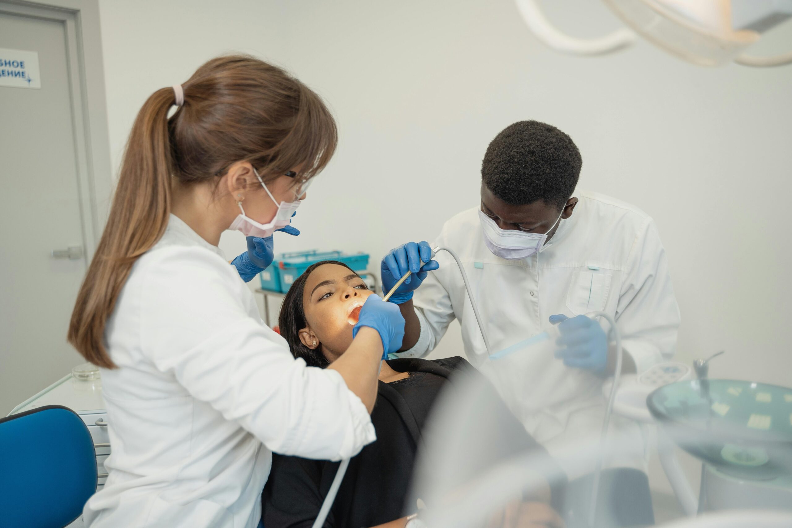 Dentists examining a patient in a dental clinic.