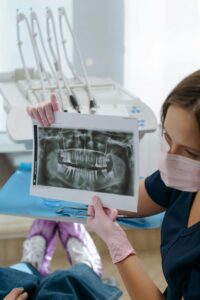 Implant Dentistry in Glendale, AZ | Smile Science Dental Spa 33 Dentist showing a dental X-ray to a patient.