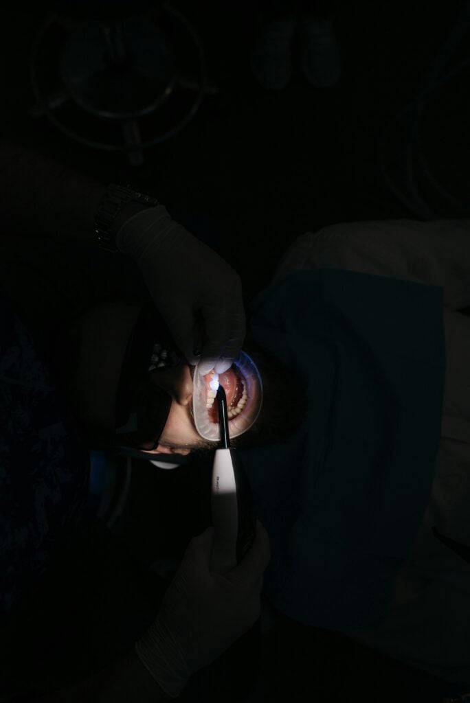 Dentist examining a patient's mouth with a dental tool.
