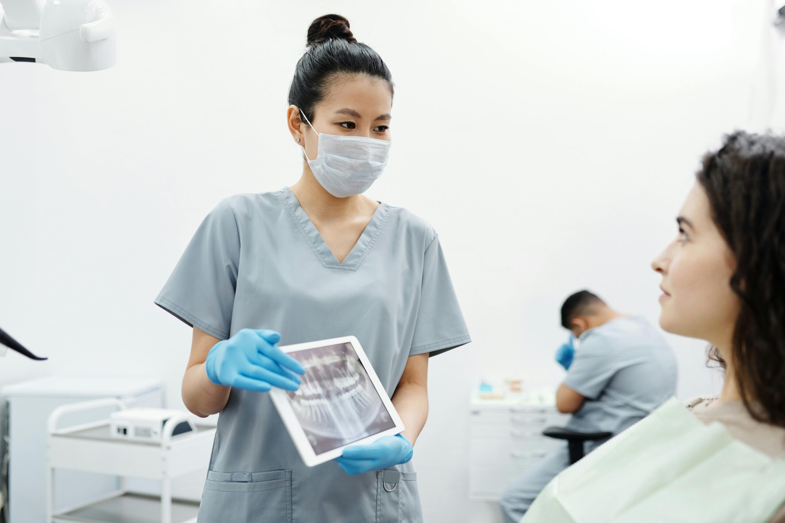 Dental professional showing X-ray to patient during consultation.