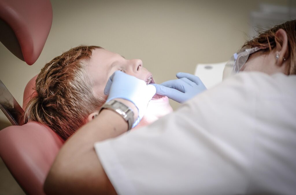 Dentist examining a child in a dental chair, addressing dental anxiety.