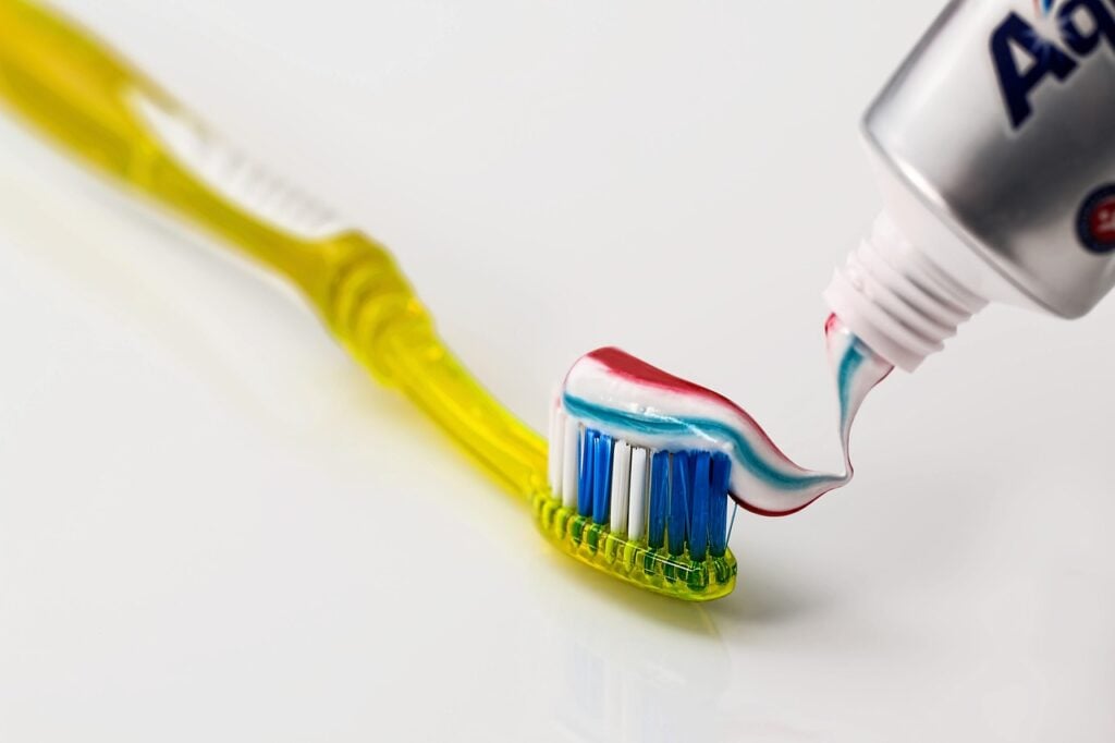 Toothbrush with toothpaste being applied.