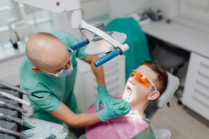 Dentist examining a patient with dental tools in a clinic.