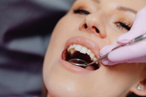 Dentist examining a patient's teeth with a dental mirror.