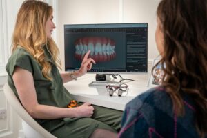 Dentist explaining invisible braces using a computer model.