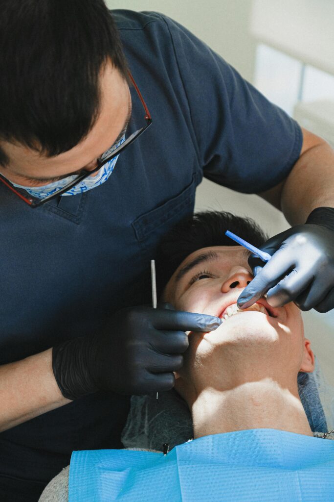 Dentist examining a patient's mouth with dental tools.