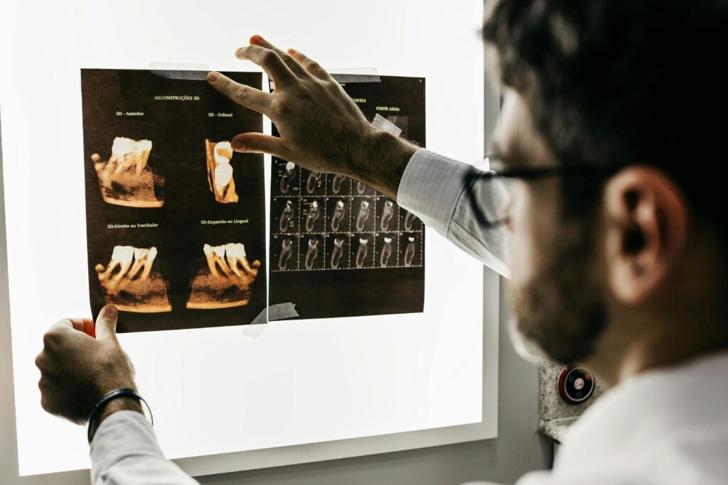 Dentist examining dental X-rays on a lightbox.