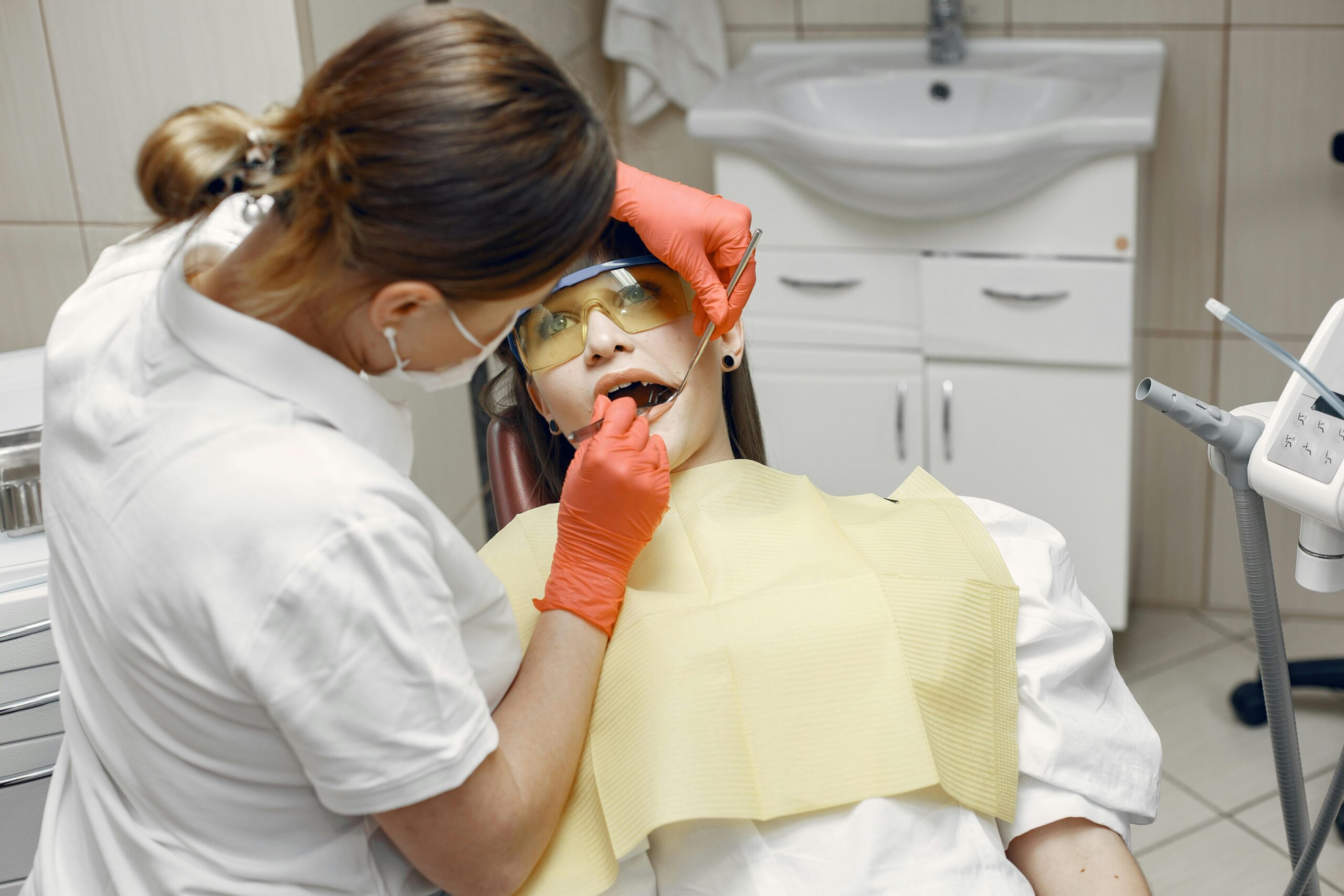 Dentist examining a patient with dental tools in a clinic.