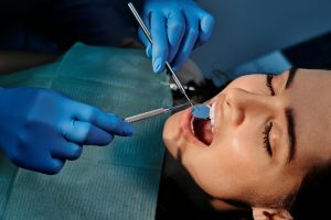 Dentist examining a patient's teeth with dental tools.