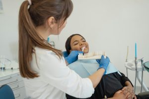 Dentist showing veneer shades to a patient in a dental office.